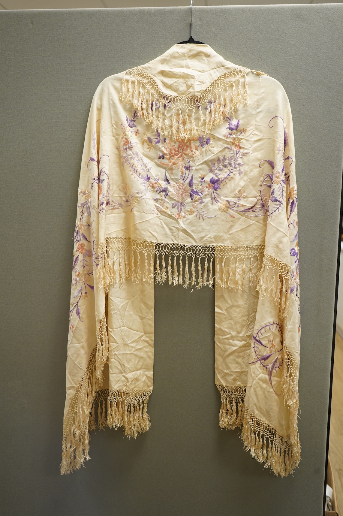 A 19th century Chinese cream silk embroidered and fringed stole, converted to a cape. Embroidered in pastel pinks and lilacs.192cm long